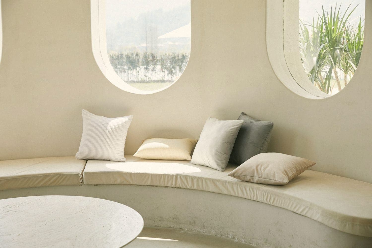 A curved banquette under round windows