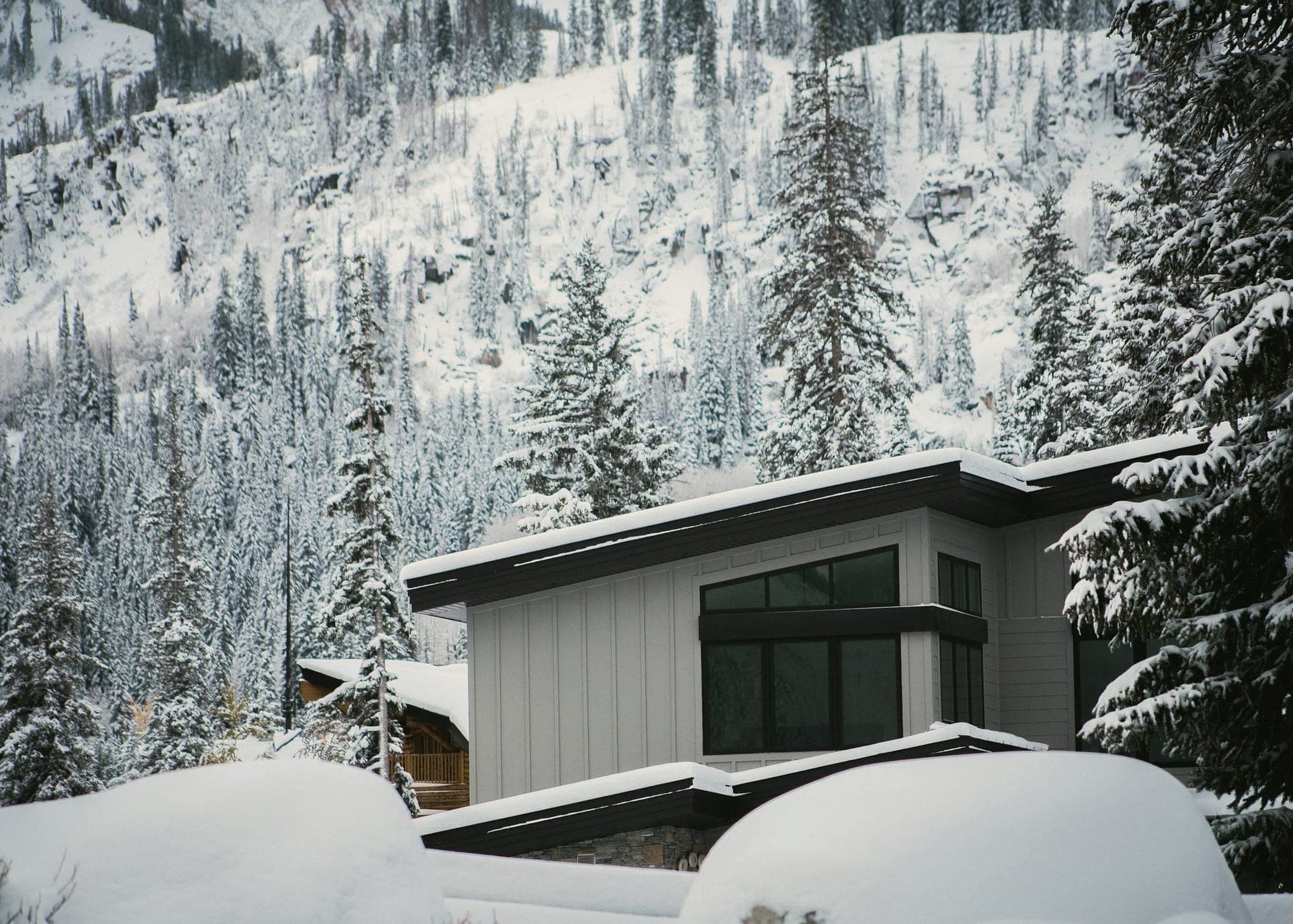A modern house in deep snow among pines