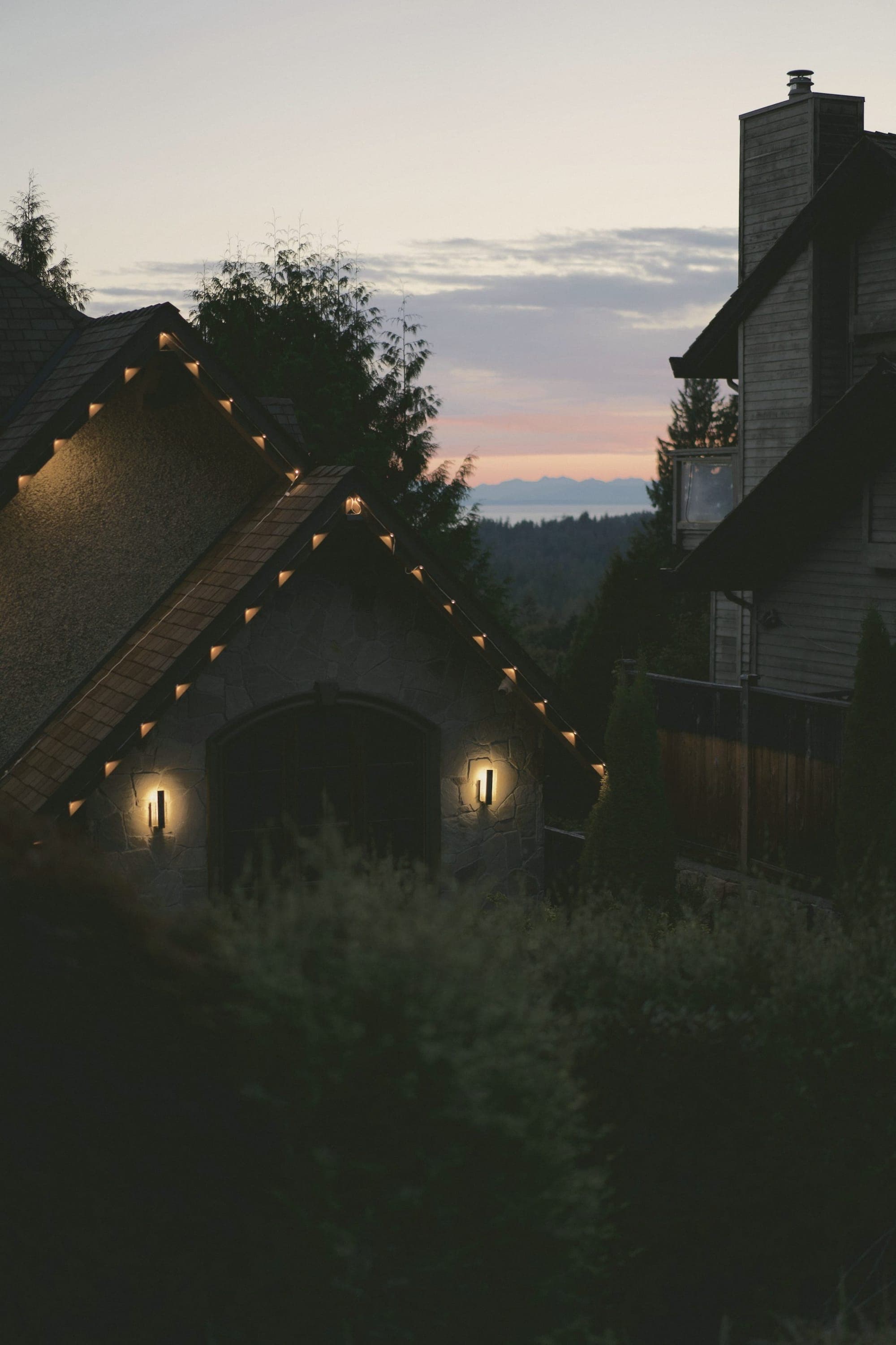 A stone house with warm lights at dusk