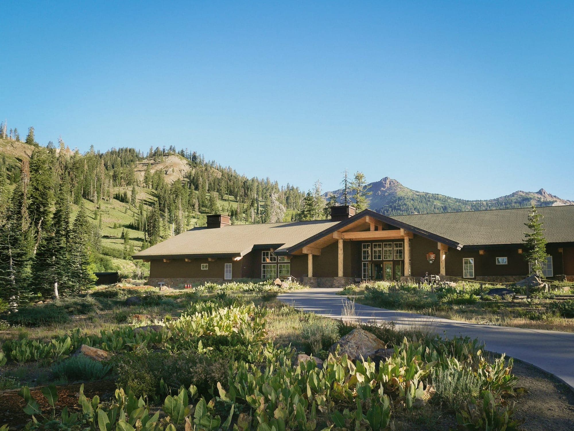 A long, low lodge below forested mountains