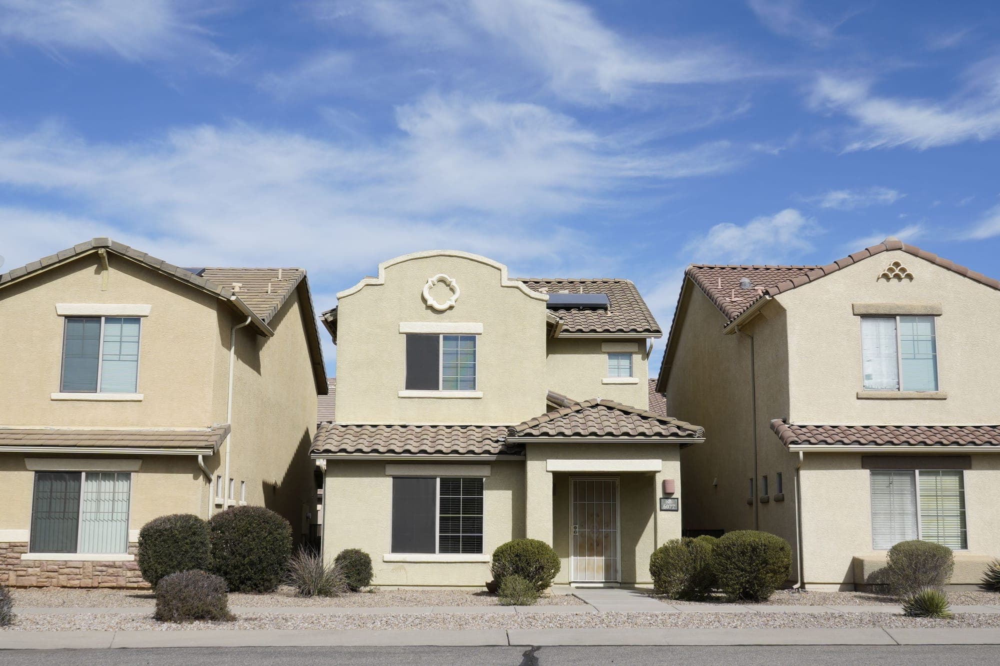 Stucco two-story homes along a suburban street